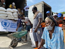 WFP/Alexis Masciarelli, An elderly woman waits to receive her food assistance, Haiti, Grand Perrin, Les Cayes. in front of a WFP truck.