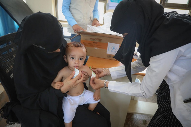 A 19 month old boy from Yemen is fed with supplementary food and is measured for malnutrition.