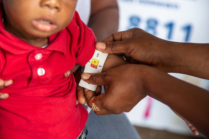 Dieuvila and her son Woodginia being measured for acute malnutrition. © WFP/Theresa Piorr