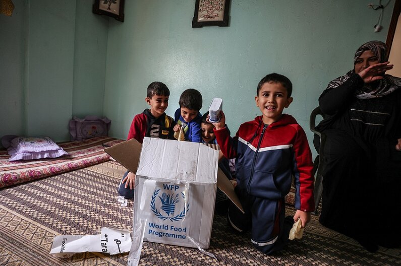 Khitam and her family of 6 have just opened a food parcel provided by WFP  © WFP/Ali Jadallah