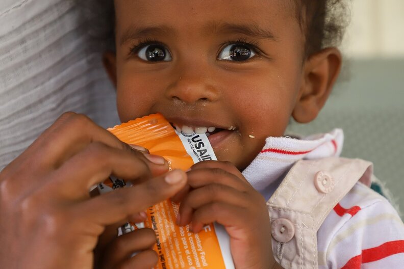 Tiemar Meles, 2 years old baby girl  having  a  plumpi-nut during a TSF distribution, in Mekelle town Tigray region of Ethiopia. © WFP/Michael Tewelde