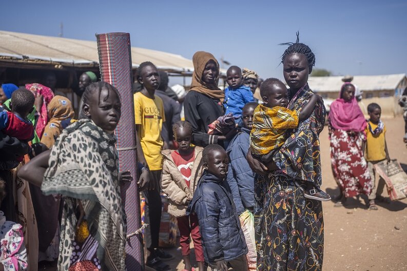 Families carry their belongings as they arrive to South Sudan after fleeing fighting in Sudan. © WFP/Hugh Rutherford