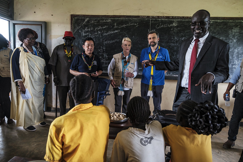 FAO/IFAD/WFP/Eduardo Soteras. Center from L to R: FAO Director-General QU Dongyu, WFP Executive Director Cindy McCain and IFAD President Alvaro Lario, talk with students in a class during a visit to the Udhaba Primary School, in the village of Udhaba, as part of the principals of Rome-based Agencies official visit to South Sudan. 