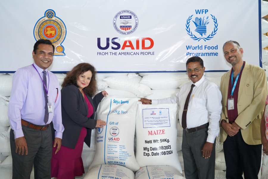 Photo: WFP/ Gallery. Asta Zimbo, USAID, hands over packs of soya & maize to Deepthi Kularathna, Chairman, Thriposha