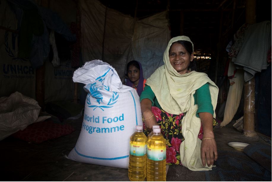 Woman with a bag of WFP food and bottles of vegetable oil