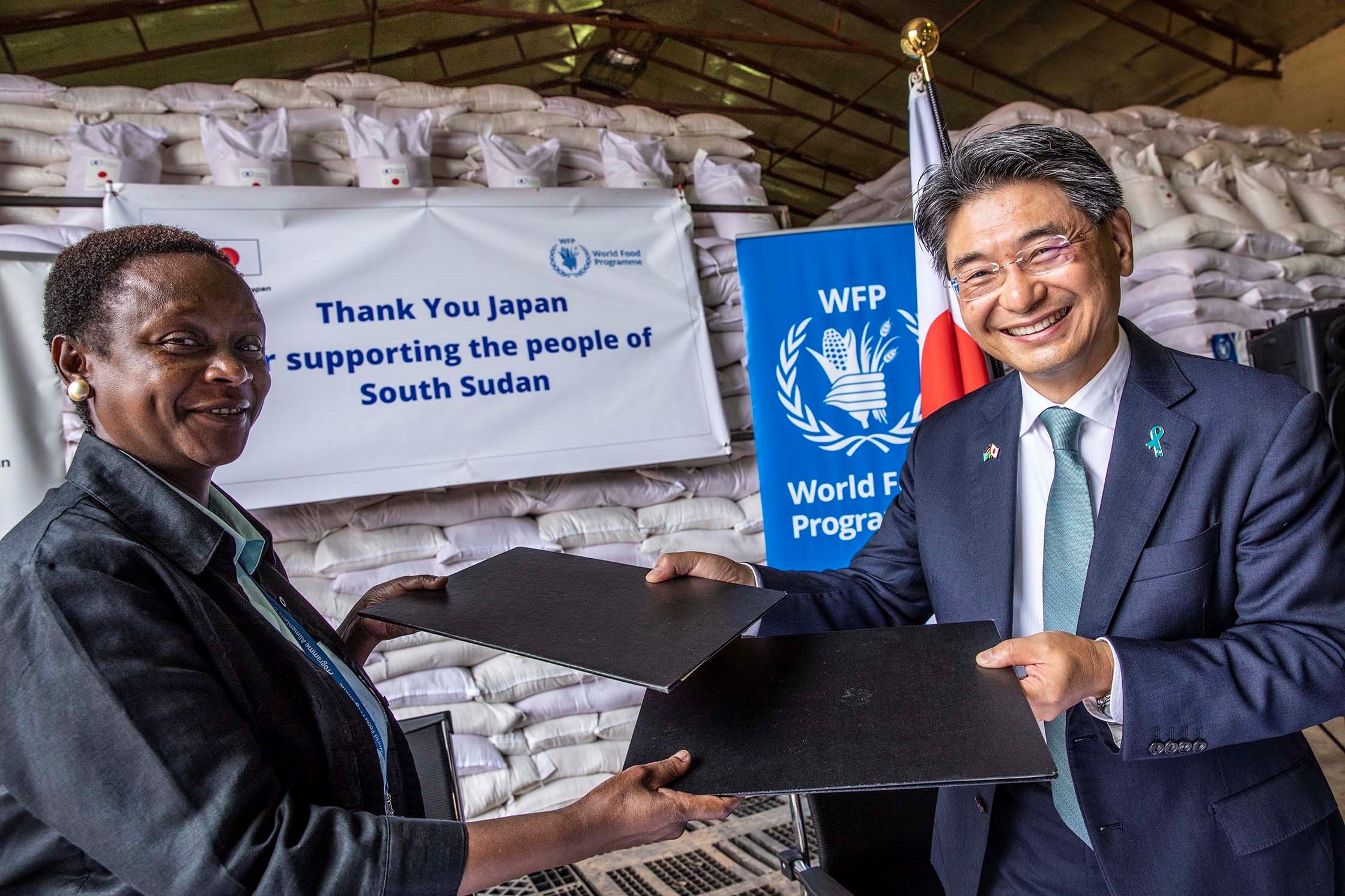 Photo: WFP/ Photogallery Makena Walker WFP’s Acting Country Director in South Sudan and TUTSUMI Naohiro, Ambassador of Japan to the Republic of South Sudan exchanging copies of  agreement at WFP’s warehouse in Juba.