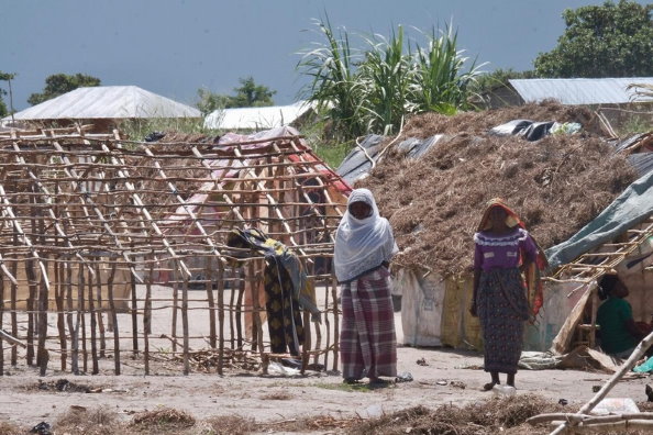 WFP/Grant Lee Neuenburg, Two women walking around precarious tents in a temporary settlement center in Palma, Cabo Delgado Province, Northern Mozambique