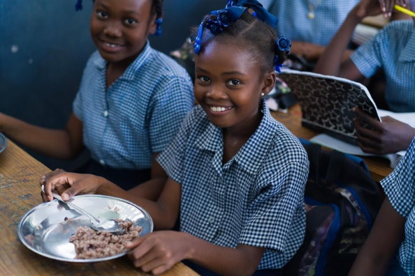 Photo: WFP/Antoine Vallas, a schoolgirl in Bouraly school, Gonaives, Haiti, who receives daily hot meals supported by WFP.