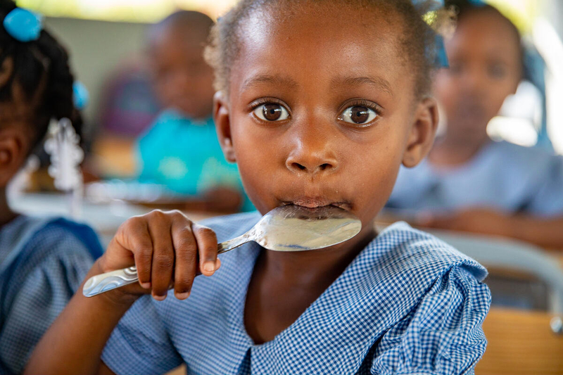 Photo: WFP/ Theresa Piorr. School girl enjoying nutritious school meal with local vegetables