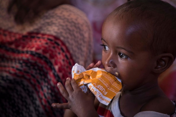 WFP/Marco Frattini, Child eating PlumpySup to treat moderate acute malnutrition (MAM).