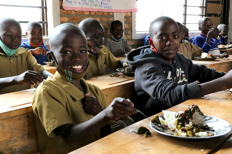 Donat, aged 9, enjoys a WFP-supplied school meal with classmates. Photo: WFP/Emily Fredenberg