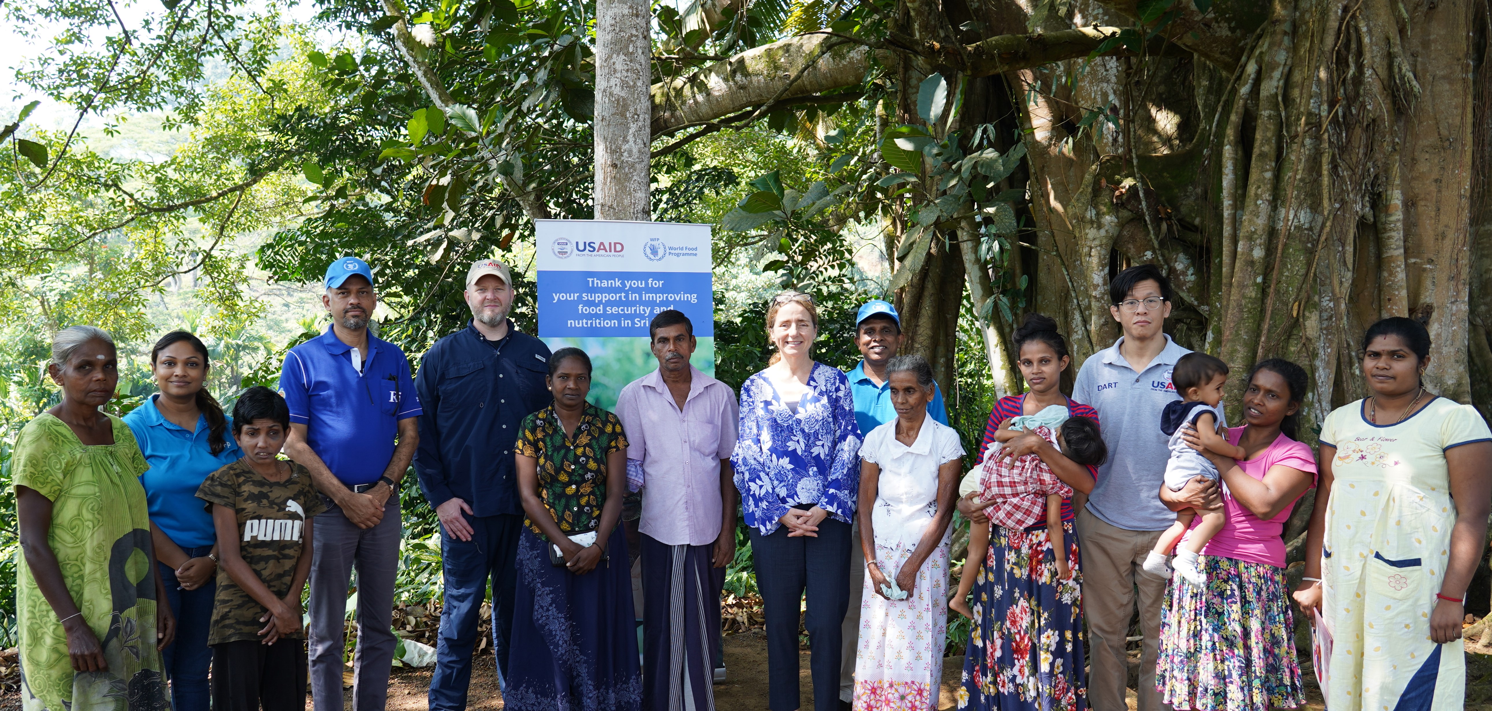 Stephanie Wilcock, Director for Asia, Latin America, and the Caribbean of USAID’s Bureau for Humanitarian Assistance with a group of people in Rathnapura enrolled to receive WFP cash assistance through USAID funding.