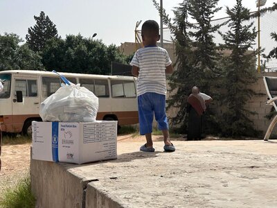 Child next to a box of WFP food.