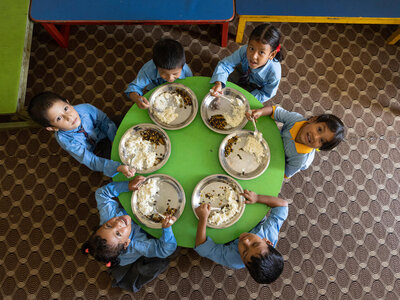A group of school children are having their school meals