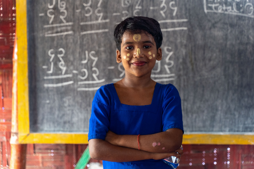 a woman is standing in front of a chalkboard