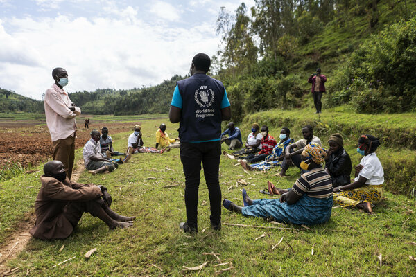 Man standing in field talking to group of people