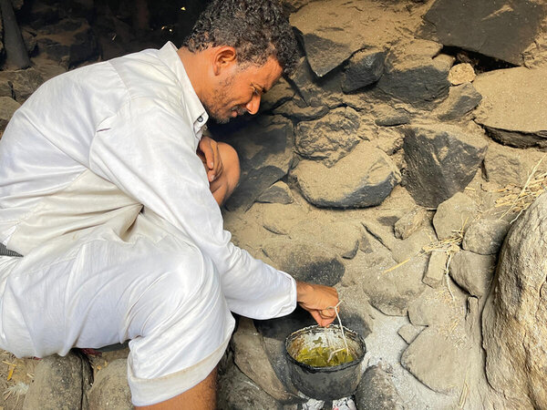 Abdullatif tending to the boiling pot on a makeshift stove 