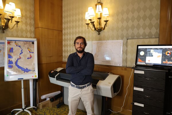 Man stood in room with maps