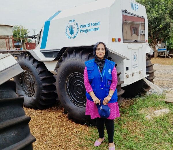 Woman standing in front of a WFP amphibious truck