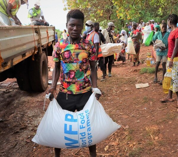 A young man carries a WFP's bag of rice after cyclone Gombe stroke. 