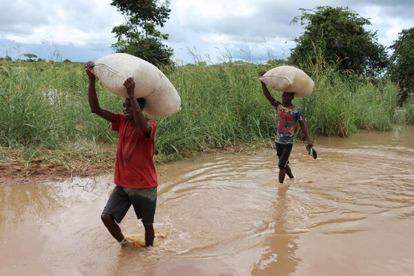 Local people are making pocket money by carrying other people and goods on their backs. 