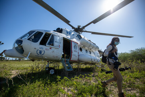 A WFP staff member leaves a helicopter