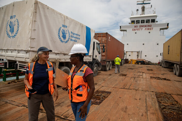 Two staff members stand onboard a ship