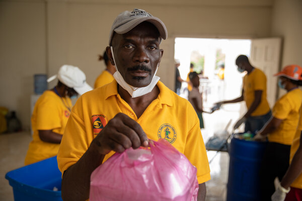 Un miembro del personal del WFP sostiene una bolsa rosa de alimentos
