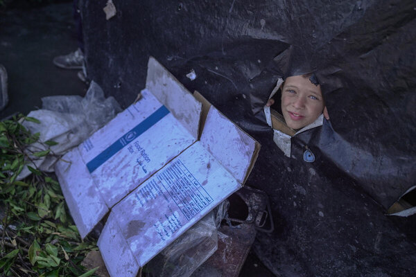 Boy peers out of leaking tent in Gaza