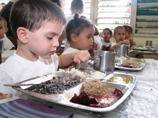 Cuban children enjoying a meal with beans and rice