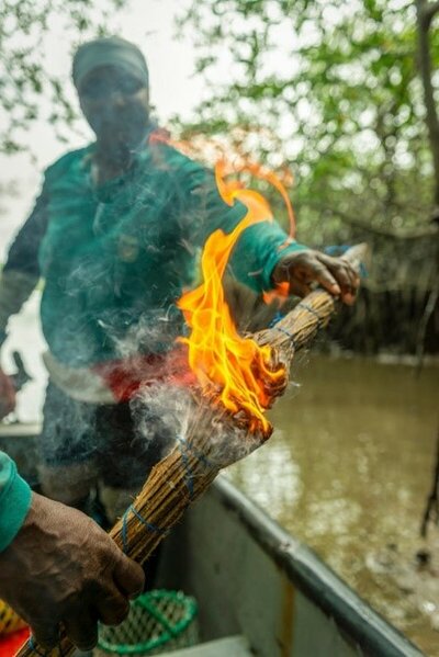 Rosa lights a wick so the smoke drives away the insects