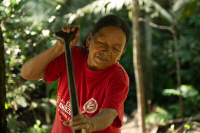 close-up of indingenous woman in red T-shirt stirring yucca flour