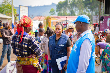 A WFP operative and a UN colleague meet refugees from DRC at the Nyakabande transit centre in Kisoro, Uganda.