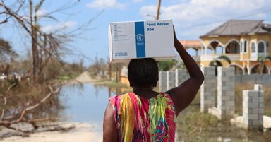 A woman returns to her house carrying a box of WFP emergency food on her head, after a distribution in support of the emergencyresponse of the government of Jamaica in the area of Arlington, St Elizabeth parish, one of the most damaged by Hurricane Melissa