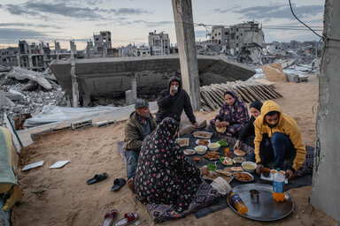 A family break their fast amid the ruins of their neighbourhood in Al-Zarqaa, Gaza City, ahead of the current escalation of conflict across the Middle East.  