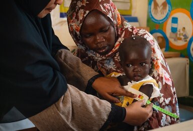 WFP nutrition staff with Duha (8 months old) girl taking her MUAC measurements in the WFP-supported nutrition centre Ahmed Gasim in Portsudan.