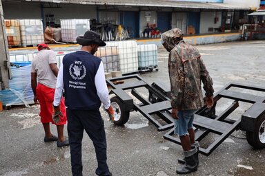 WFP Man in WFP vest and others move boxes in preparation for hurricane response