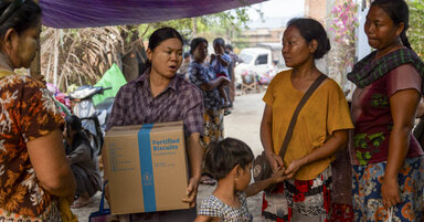 A group of women receive a box of WFP fortified biscuits in Myanmar