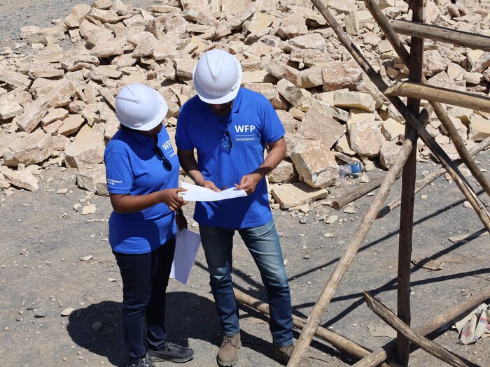 Two staff wearing WFP vests are working 