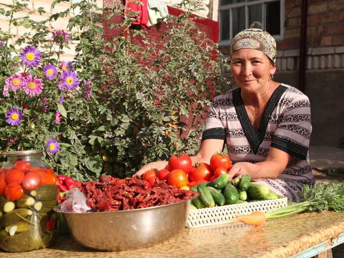 A woman is preparing food with vegetables in the garden