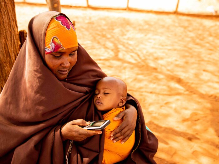 Malyun Abdullai Abdi receives mobile money to buy what she needs