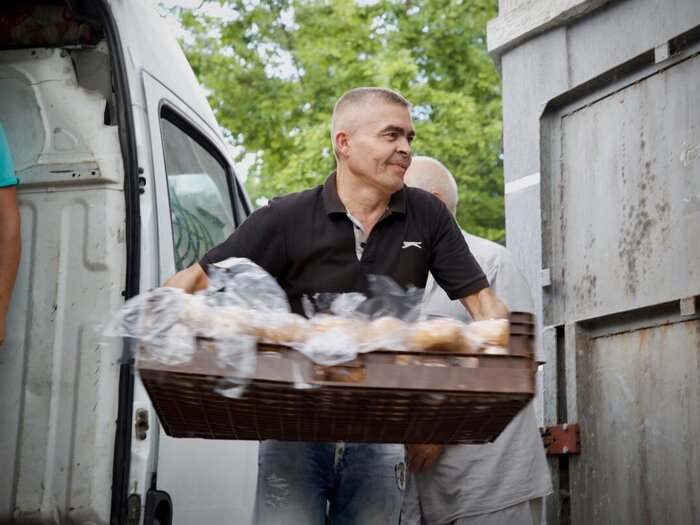 A man carrying a tray of bread