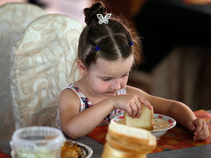 Young Ukrainian refugee eating her hot meal in the canteen of a Refugee Accommodation Centre in Chisinau, Moldova.
