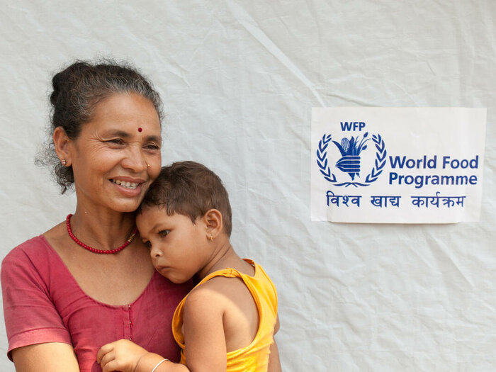 Usha Basnet, with her 27 month old grandchild Sabina, is happy to see the new health clinic being established in her village and comforts.