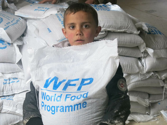 Child with a sack of food item distributed by WFP