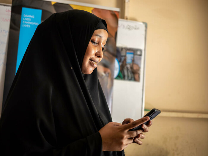 Hani Mohamed (24) uses her mobile phone to order food from an online E-shop at a WFP food distribution Centre at K4 area in Mogadishu.