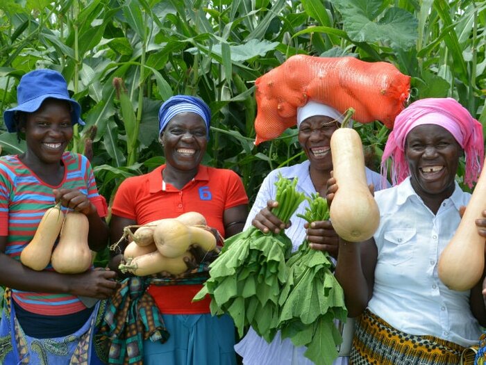 Group of female smallholder farmers with their harvested crops