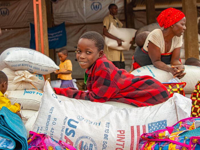 Child lying on sacks of nutrient-rich food items distributed by WFP in response to the alarming levels of food insecurity in Burundi