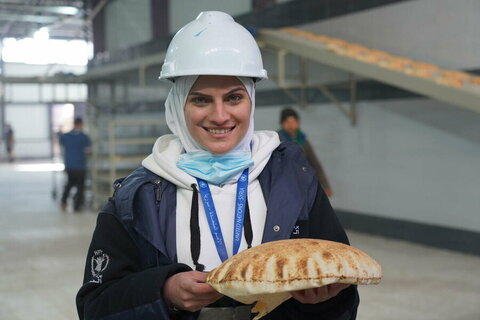 Lamya with one of the first pieces of bread the Sakhour bakery produced. Photo: WFP/Hussam Al Saleh