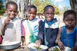 Left: The ShareTheMeal app is the world's first app to fight global hunger. Right: School children share a meal in Mozambique. Photo: WFP/Ricardo Franco